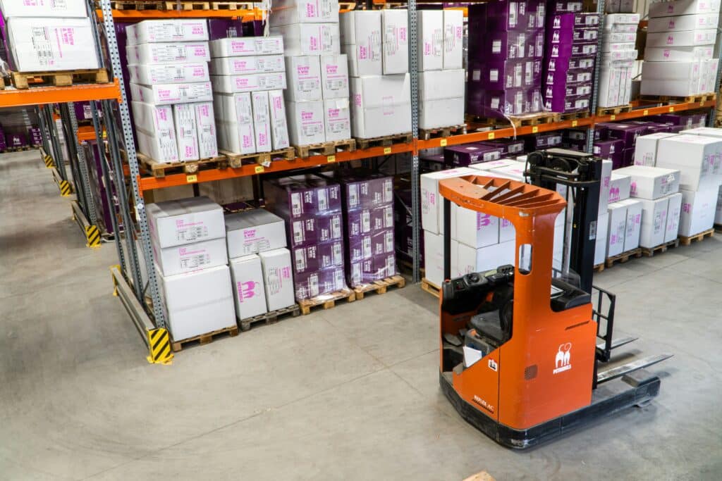 Warehouse employees organize their inventory with a forklift