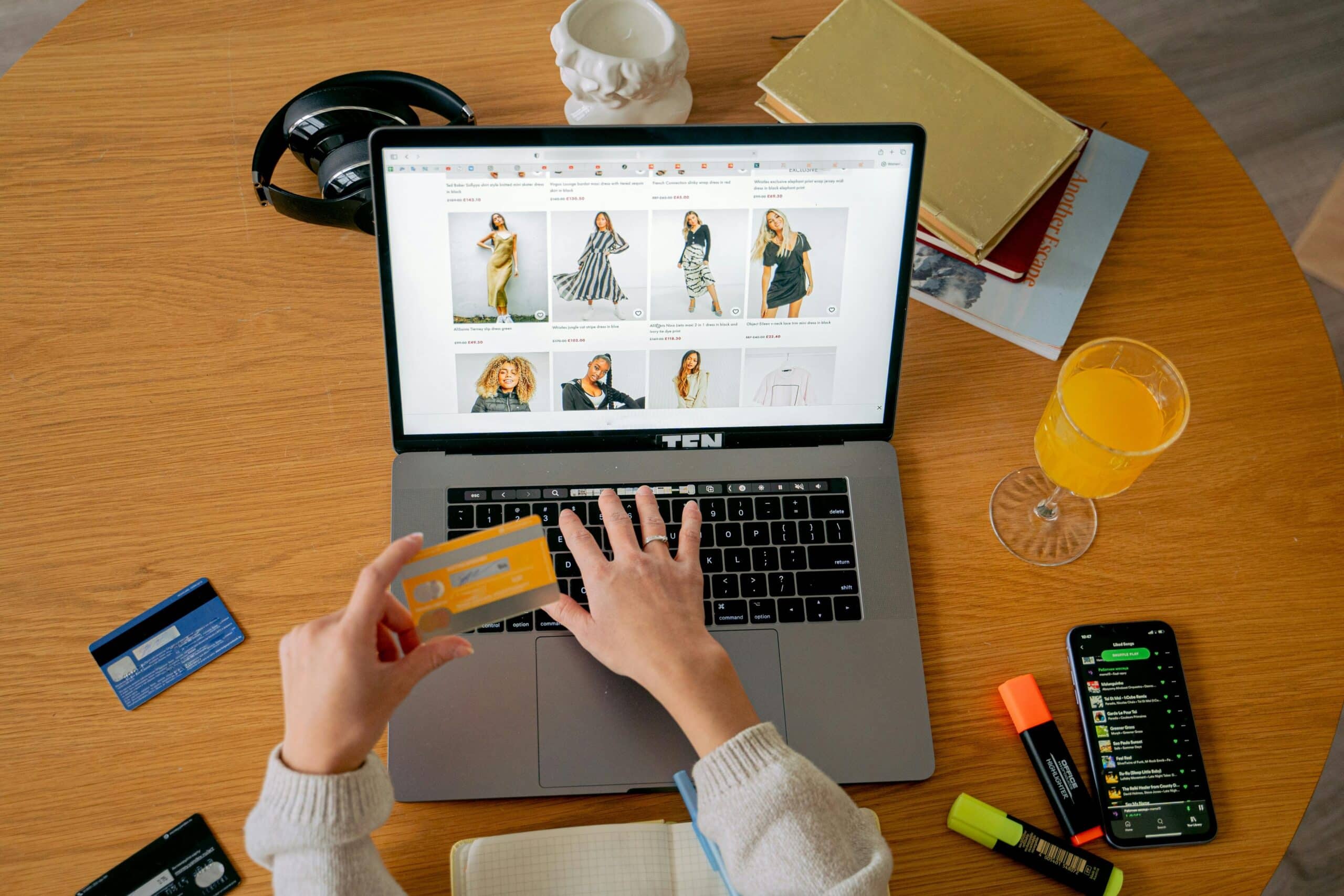 a shopper holds a credit card as they make a purchase on an ecommerce website on their laptop
