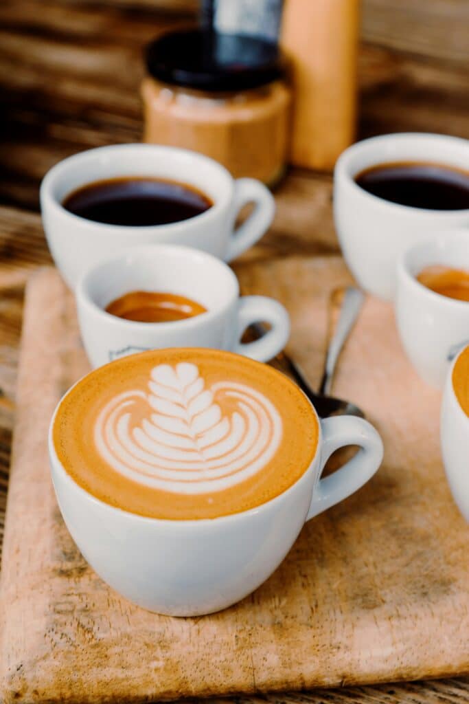 a latte, espresso, and drip coffee sit in different sized porcelain cups