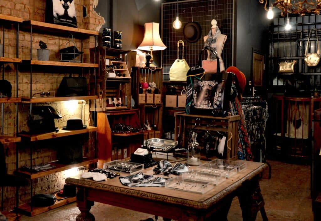 Boutique retail store with a large display area in the center and hats, bags, glasses, and garments on the shelves