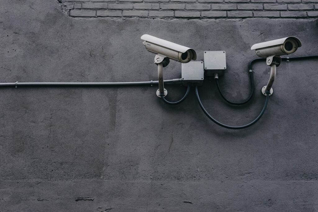 Two security cameras are mounted onto the side of a building